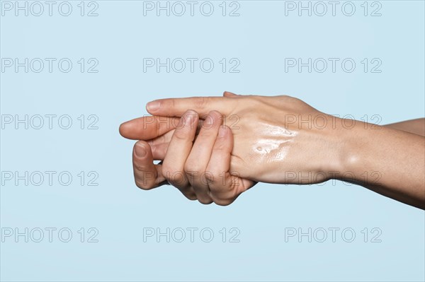 Side view woman washing hands isolated blue