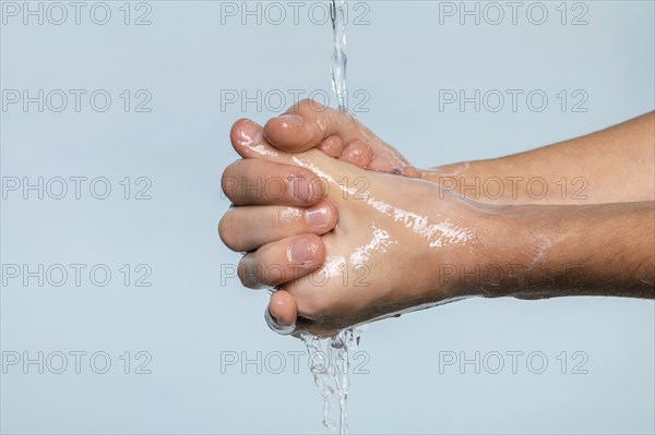 Sideways person washing hands isolated blue