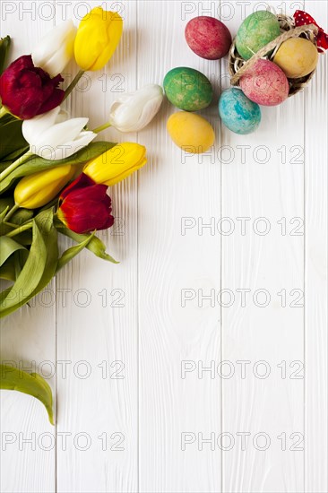 Small basket with eggs near tulips