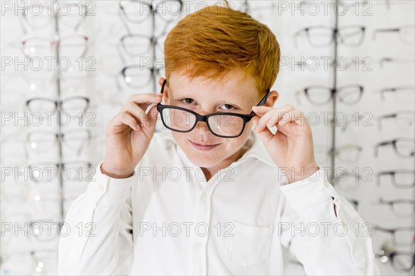 Smiling boy with freckle his face wearing spectacle looking camera