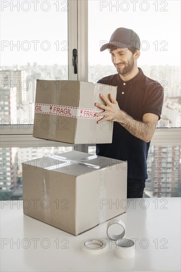 Smiling delivery man holding parcel