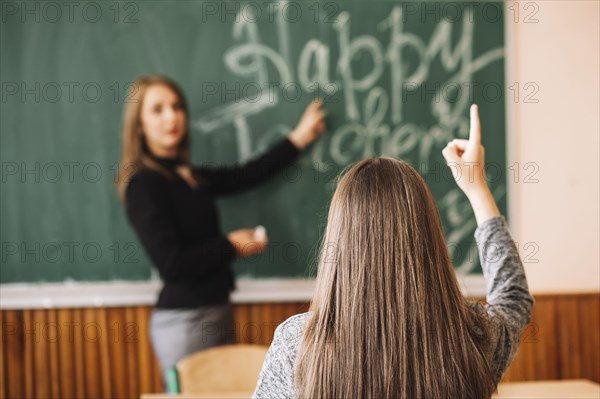 Teacher asking pupil raise her hand