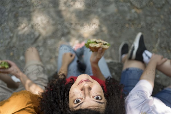 Teenagers outdoors together enjoying burger