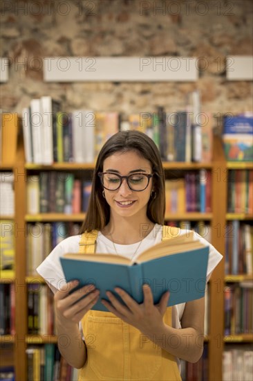 Teenage schoolgirl looking library book