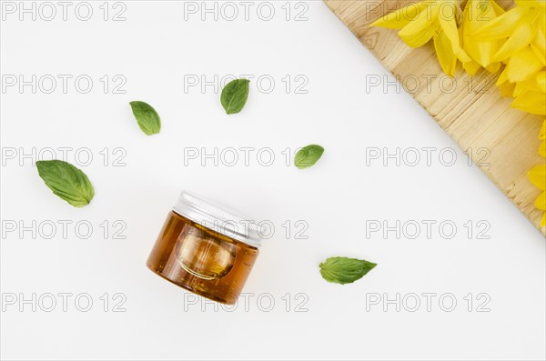 Top view close up shot jar honey with flowers leaves