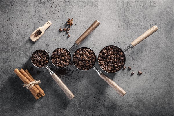 Top view coffee beans cups with scoop cinnamon sticks