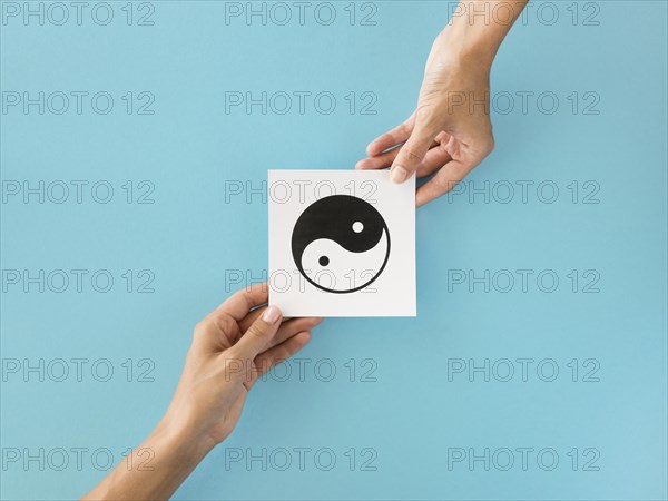 Top view hands exchanging ying yang symbol