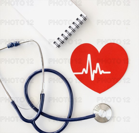 Top view notepad with stethoscope paper heart