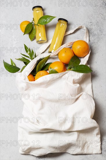 Top view oranges tote bag with juice bottles
