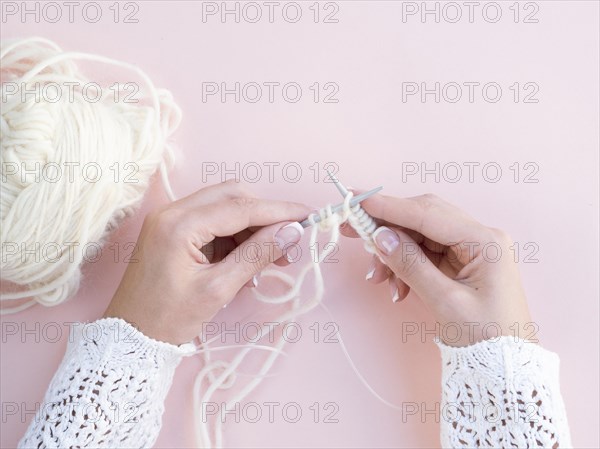 Top view woman crocheting white wool