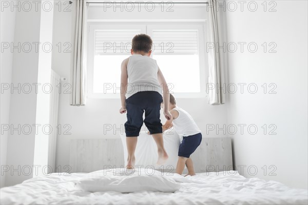 Two brothers playing bed