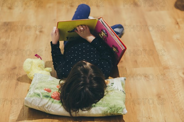 Unrecognizable girl reading toy book