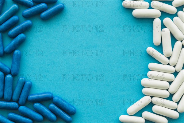 White blue candy capsules forming frame cyan background