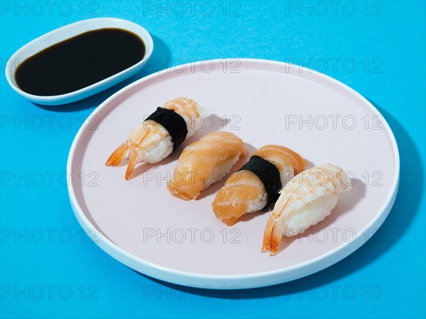 White sushi plate soy sauce bowl blue background