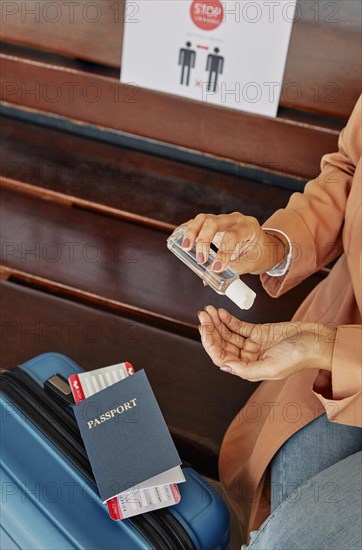 Woman applying hand sanitizer airport during pandemic