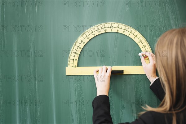 Woman drawing geometrical figure blackboard