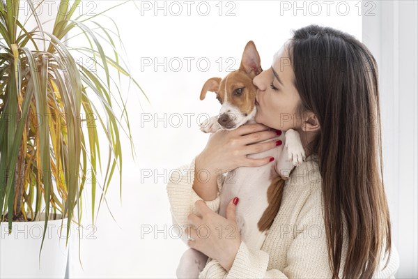 Woman giving her cute dog kiss