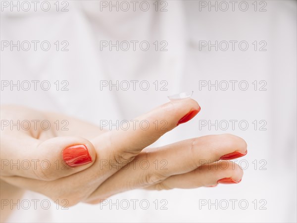 Woman holding contact lenses her finger