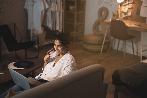 Woman holding credit card working home