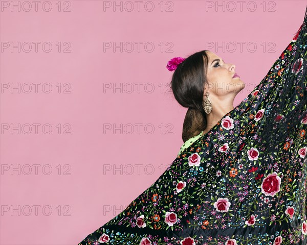 Woman holding manila shawl looking up