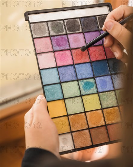 Woman s hand holding palette eye shadow powder