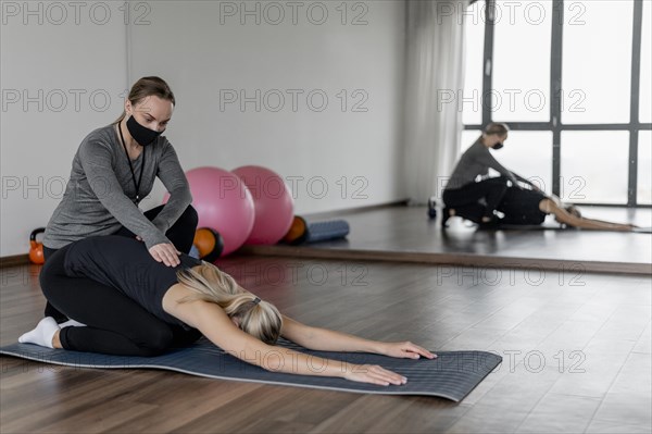 Workout with personal trainer stretching back