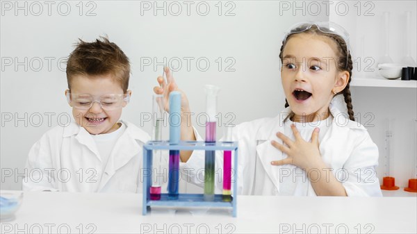 Young child scientists having fun doing experiments laboratory