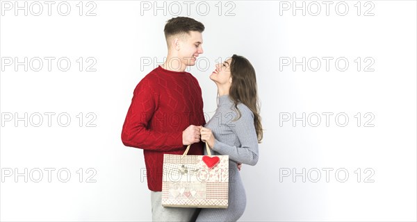 Young couple standing with gift bag