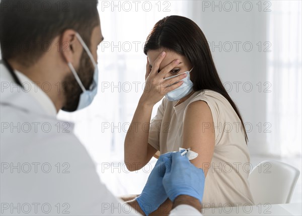Young doctor doing vaccine frightened patient