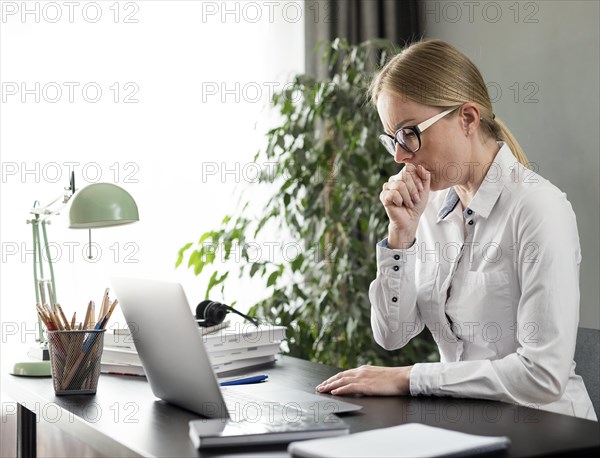 Young teacher doing her classes online coughing
