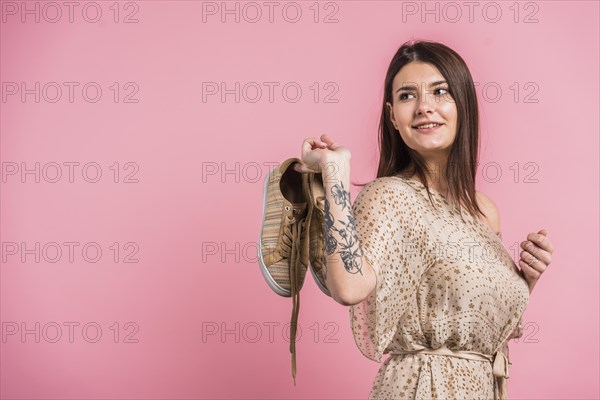 Attractive positive woman holding shoes