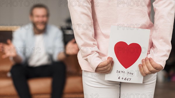 Back view little girl giving father card father s day