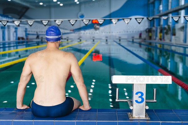 Back view man standing edge pool