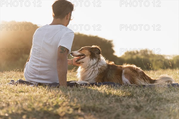 Back view young man with dog seaside