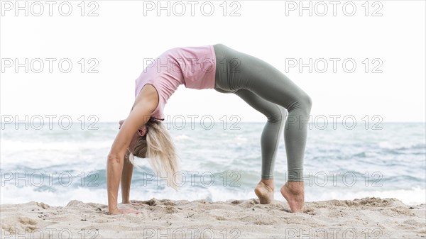 Beautiful woman doing yoga beach