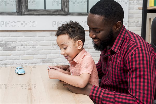 Black father son using tablet