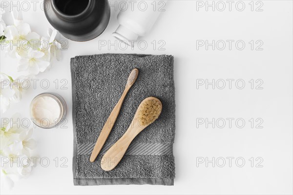 Black towel brush moisturizing cream flowers container white background