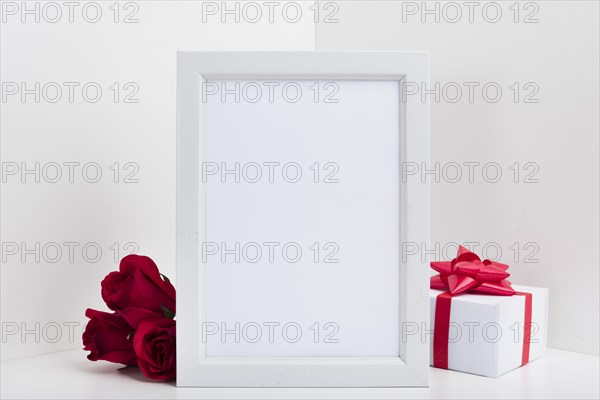 Blank frame with gift box red roses