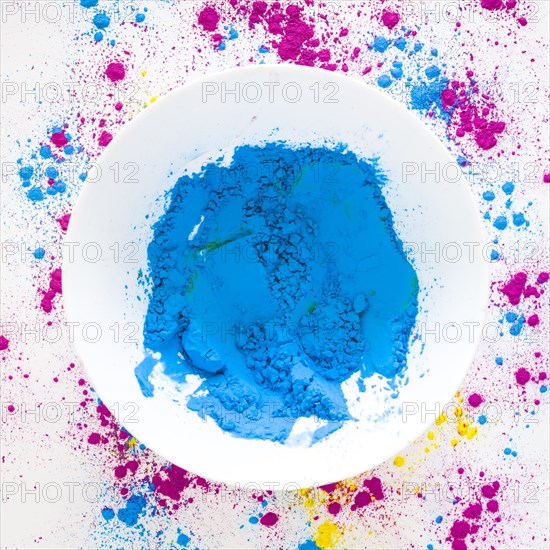 Blue holi color powder white bowl white backdrop