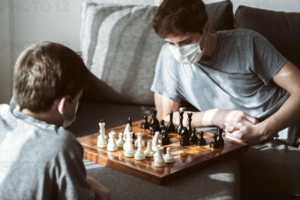 Boys playing chess home while being quarantined