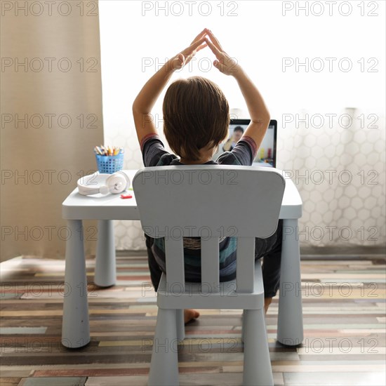 Boy talking with his teacher gesturing online school