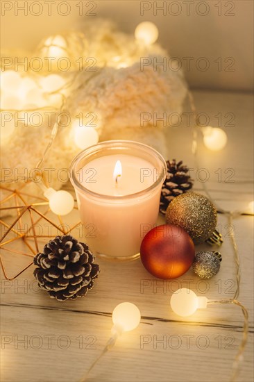 Burning candle with scarf wooden table