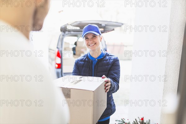 Cheerful courier giving package client