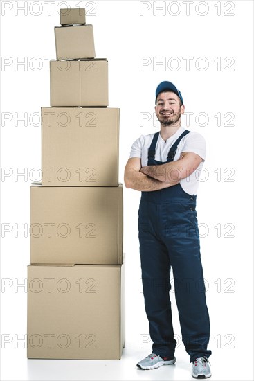 Cheerful courier near stack boxes