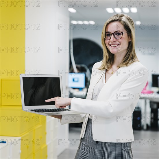 Cheerful woman pointing laptop display