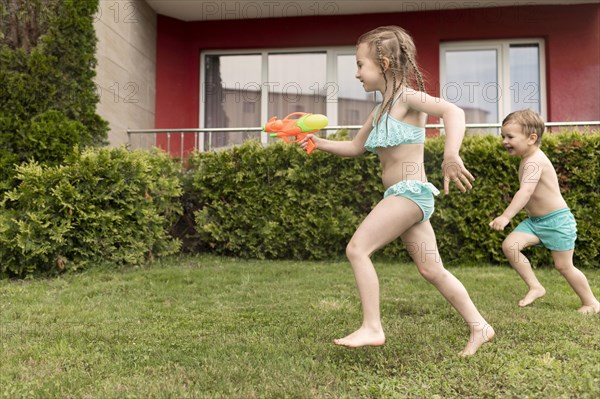 Childrens playing with water guns pool