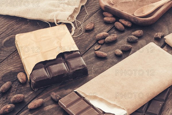 Chocolate bar with cocoa beans wooden table