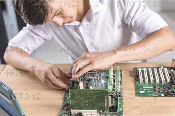 Close up it male technician repairing computer mainboard