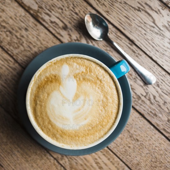 Close up latte coffee with creative latte art wooden textured background