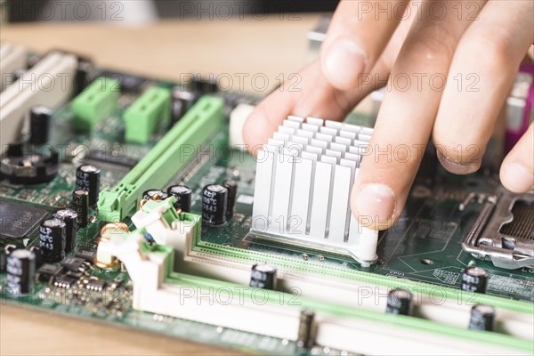 Close up male technician hand s installing heatsink computer main board